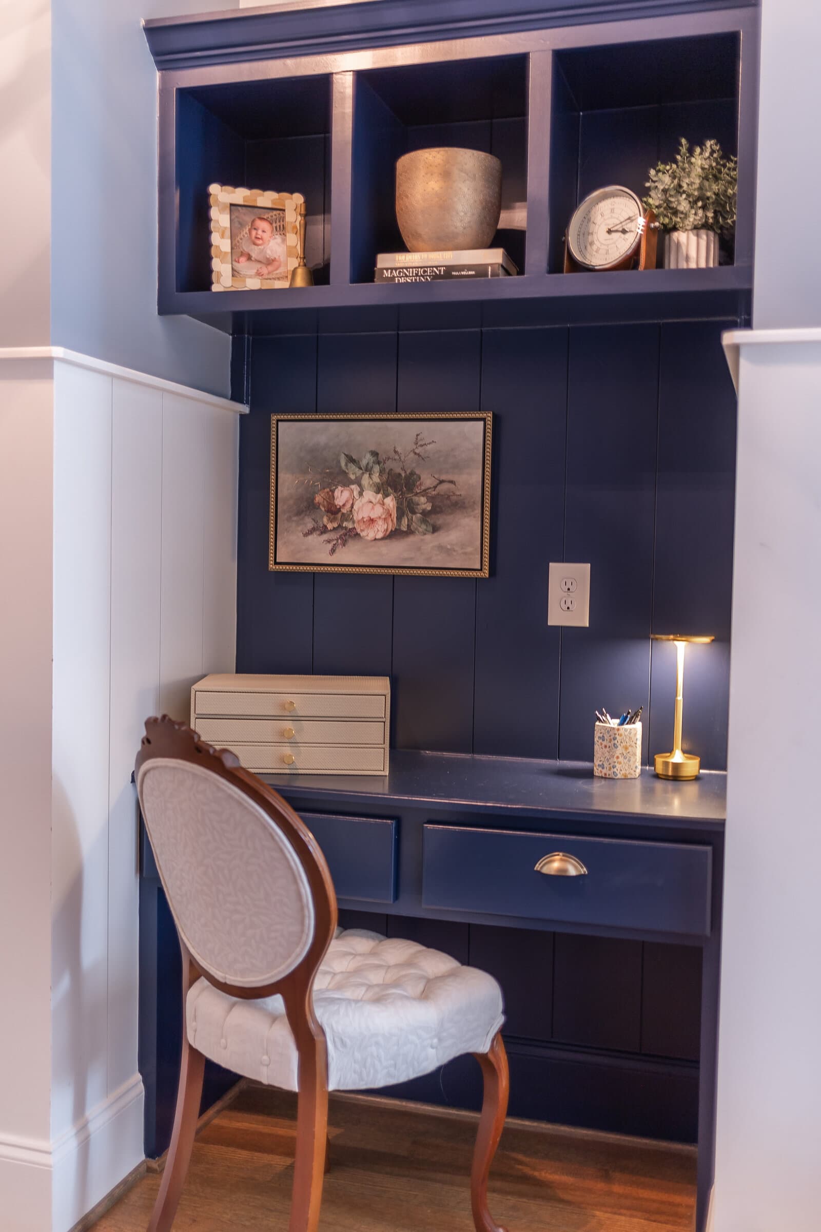 A styled shelf with books, ceramics and greenery